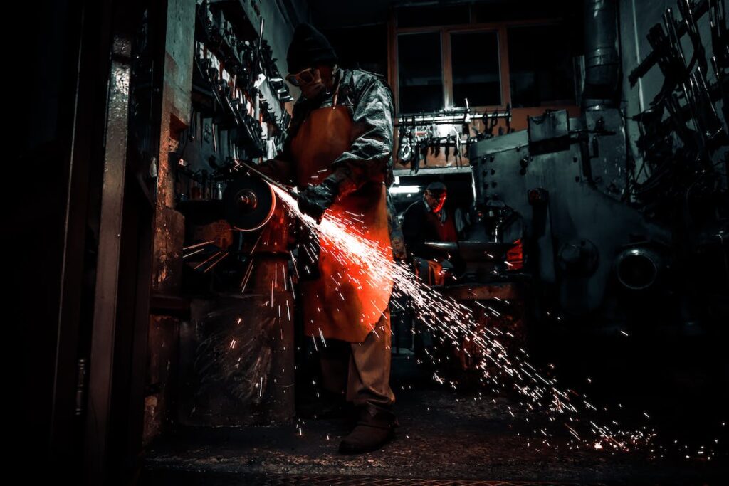 image of a machine shop with a factory worker using a machine to cut metal